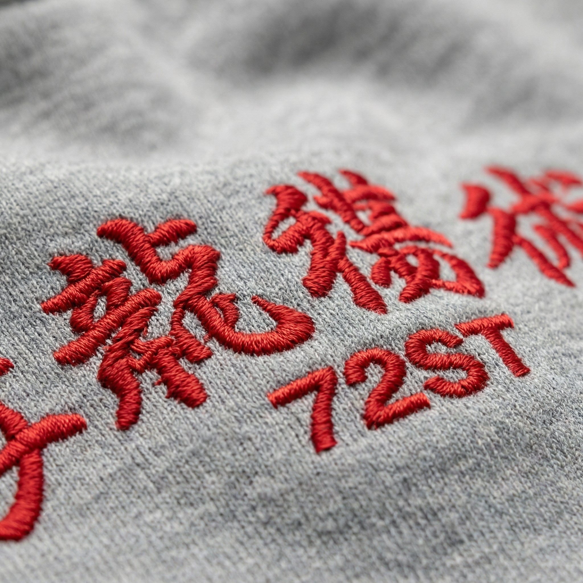Close-up red 72ST embroidery detail on gray long sleeve